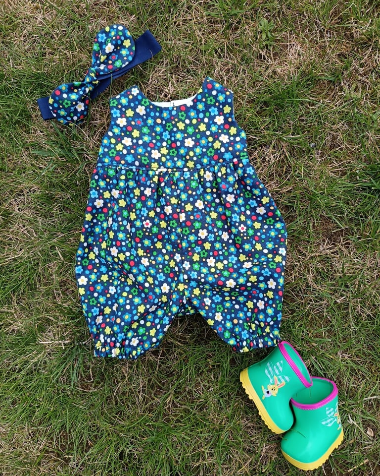 Wollyonline BD1624 view E romper in dark floral print with matching hair bow