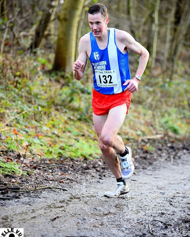 a man running on a trail in the woods