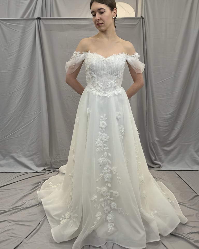 a woman in a wedding dress standing in front of a white backdrop