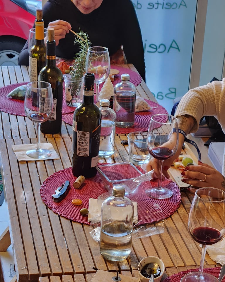 a group of people sitting at a table with wine glasses and wine bottles