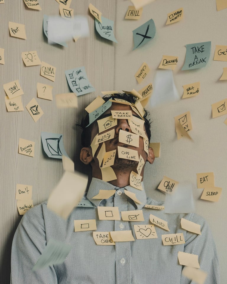 Gestresster Mann hat zu viele Aufgaben auf Post It Zetteln.