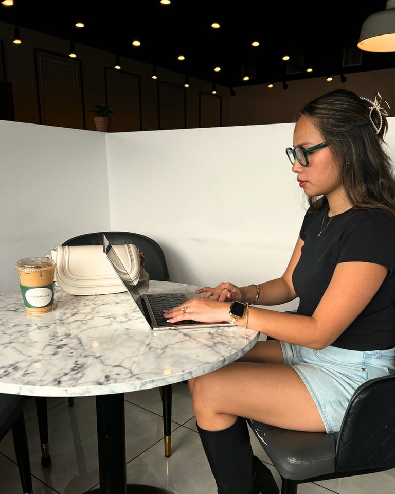 a woman sitting at a table with a laptop
