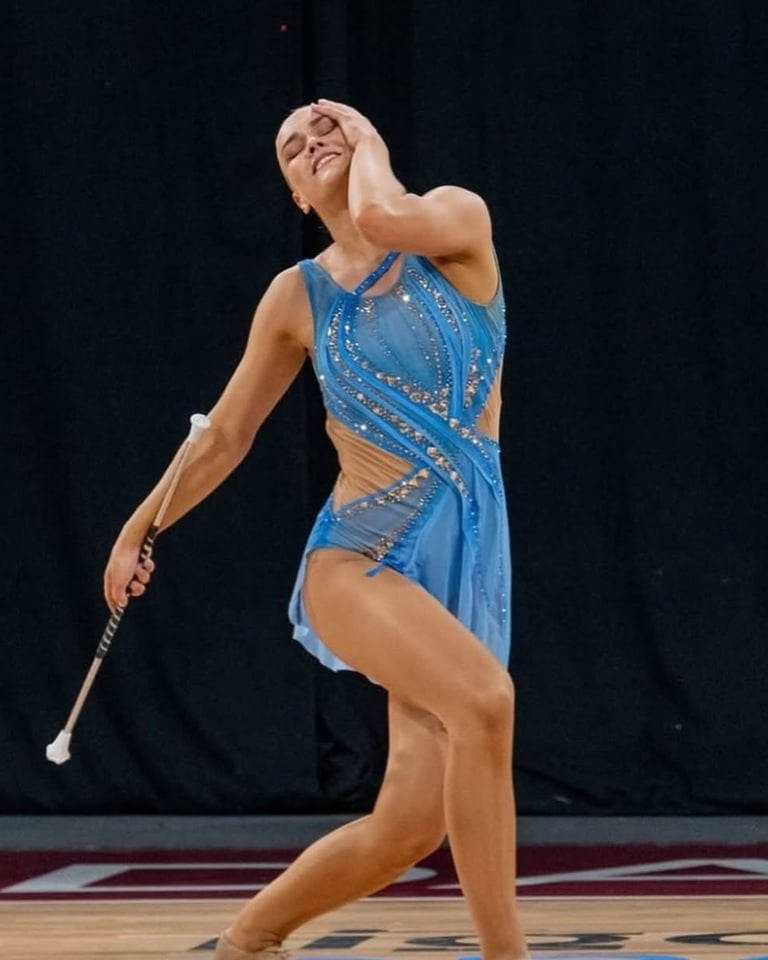a woman in a blue dress during a twirling competition