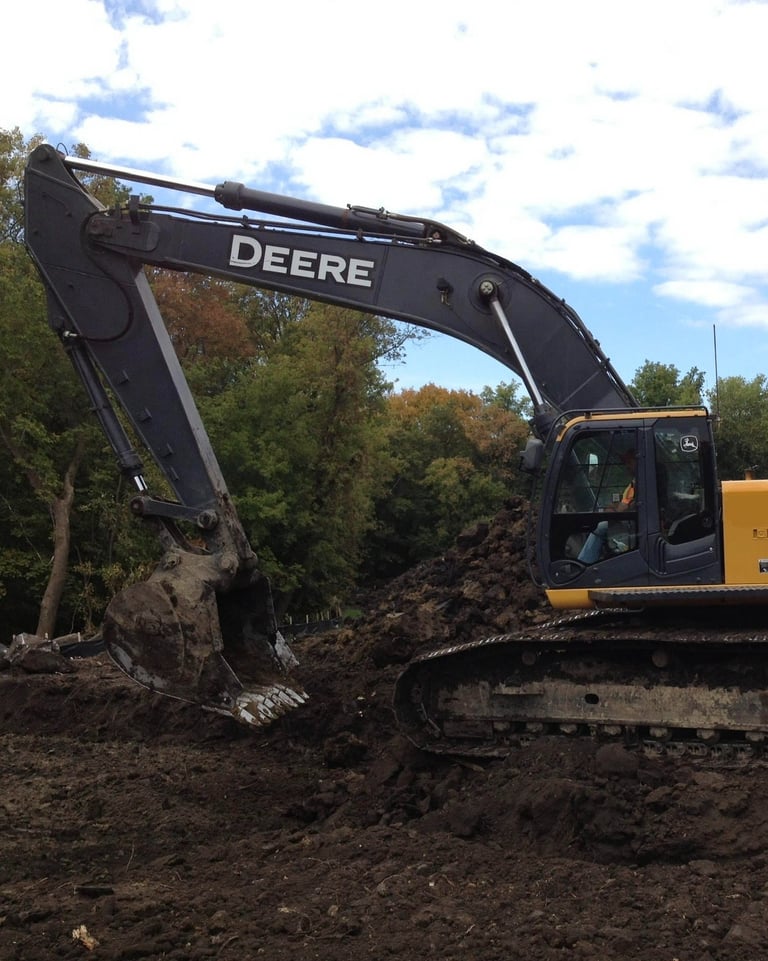 John Deere Excavator digging up dirt