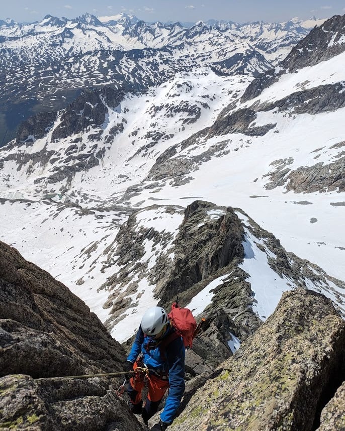 a man climbing a mountain in the alps