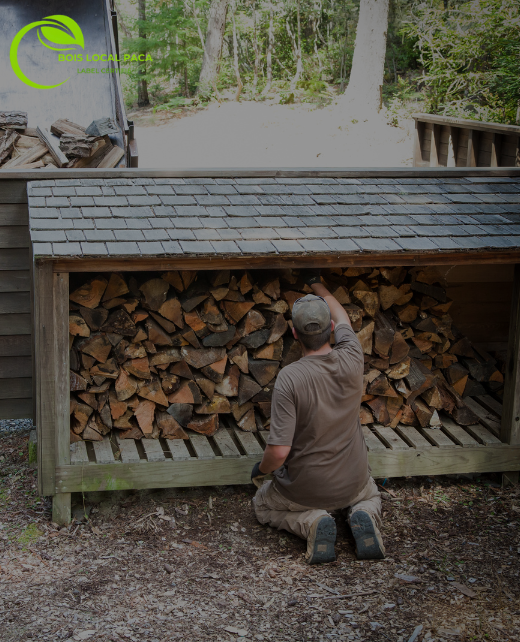 un homme travaille avec les bûches, en empilant les unes sur les autres