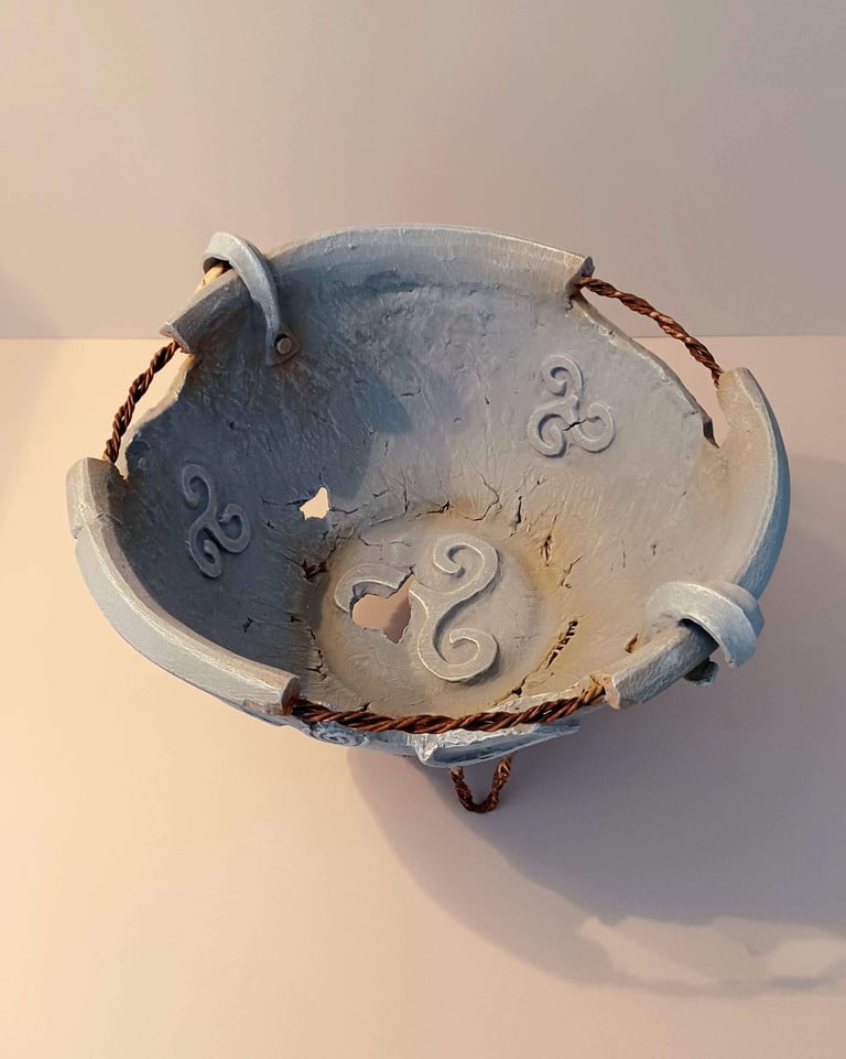 Interior of a round bowl-like sculpture with rusty wire, symbols and letters