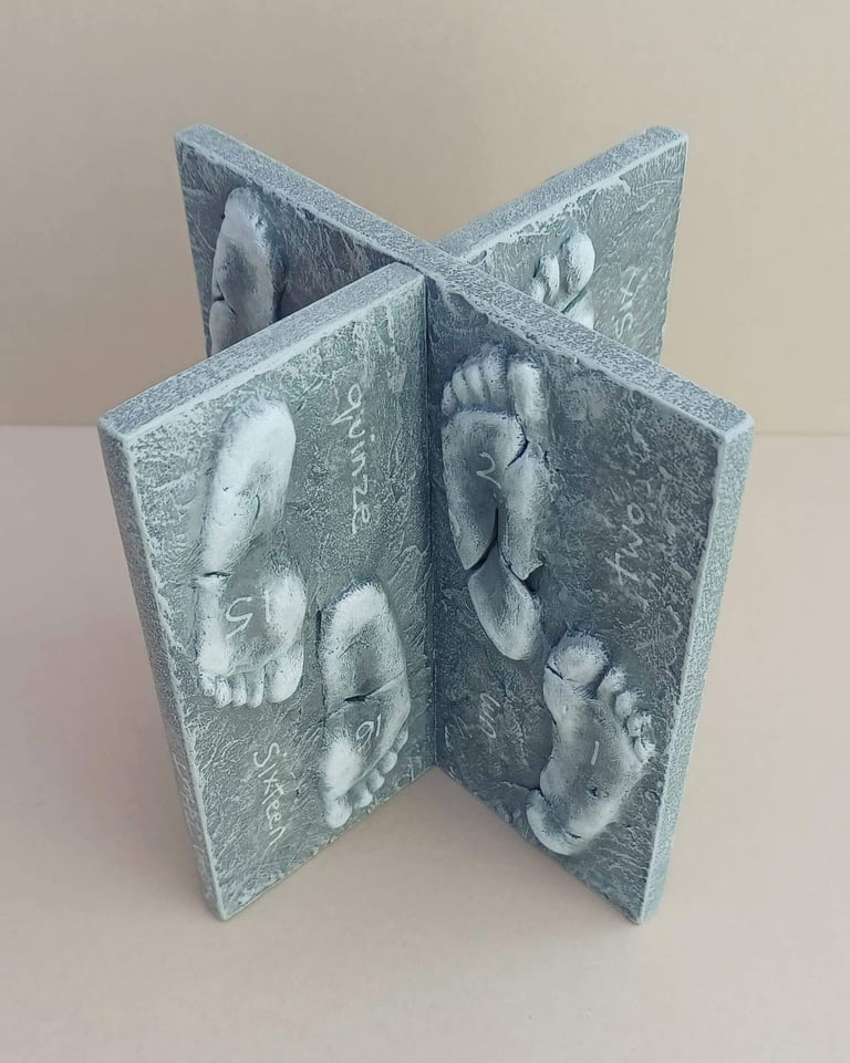 Two intersecting relief sculptures forming an X shape, and depicting three dimensional footprints.