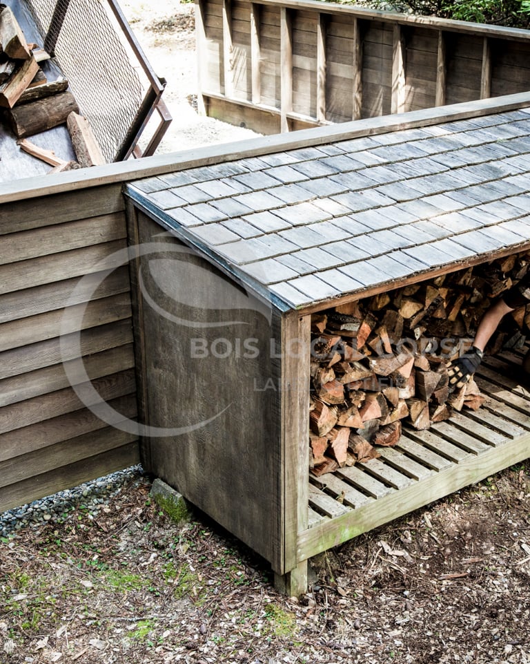 un homme travaille sur une pile de bois