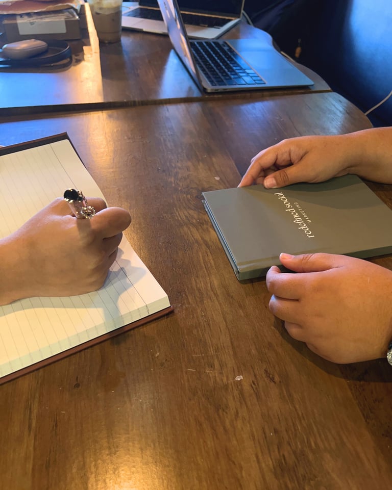 a person holding a book and a notebook