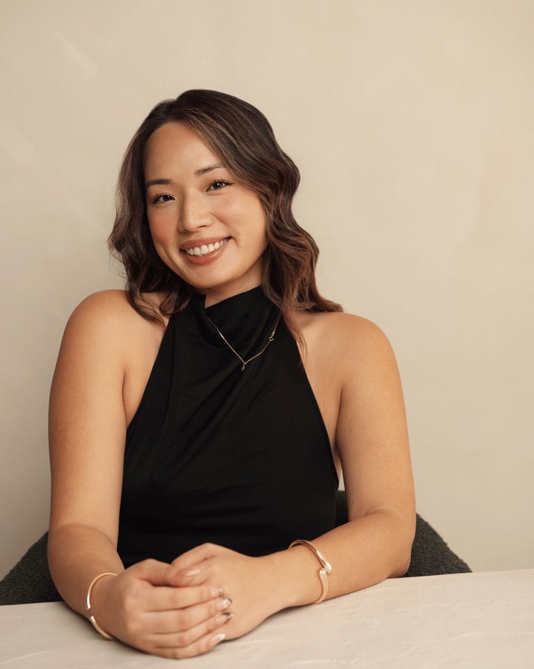 a woman in a black dress sitting at a table