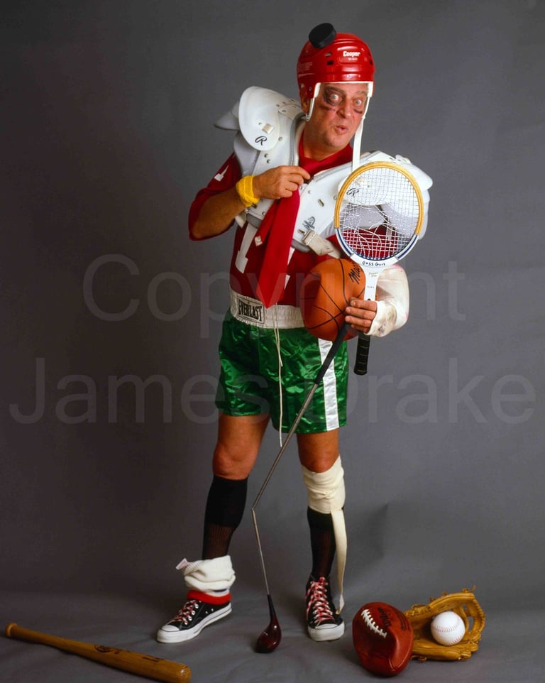 Actor and comedian Rodney Dangerfield poses with sports equipment in 1983 by James Drake