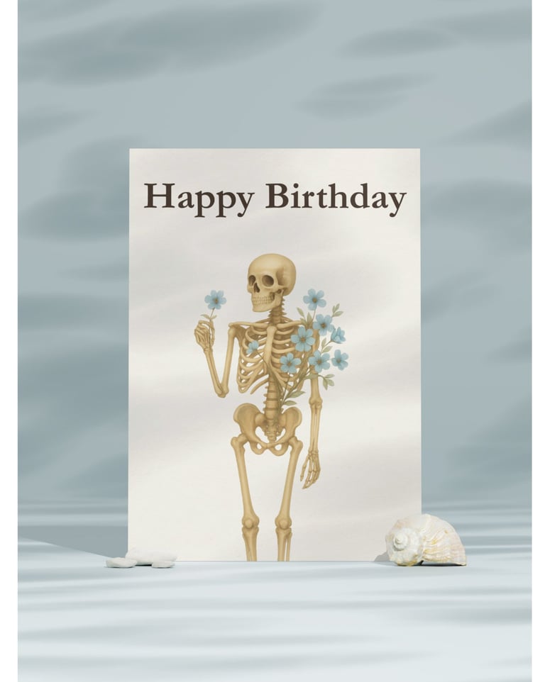 Gothic happy birthday card featuring a skeleton holding blue flowers on a minimalist aesthetic background.