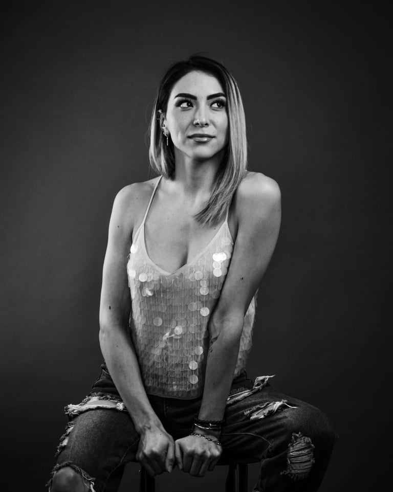 Retrato en blanco y negro de una mujer que lleva una blusa de lentejuelas y vaqueros desgastados.