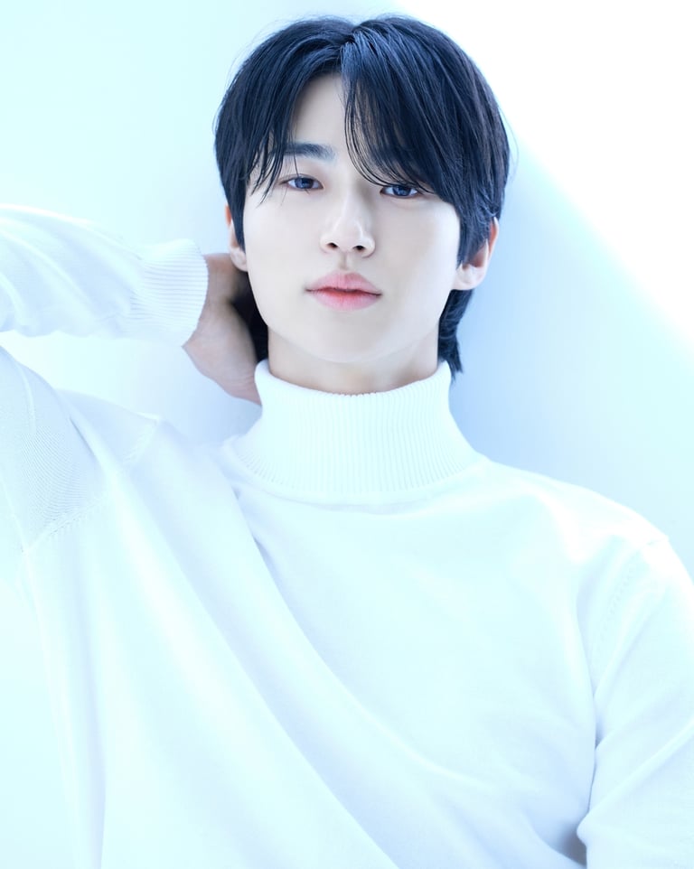A young man with black hair wearing a white turtleneck sweater in a bright, Byeon Woo-seok