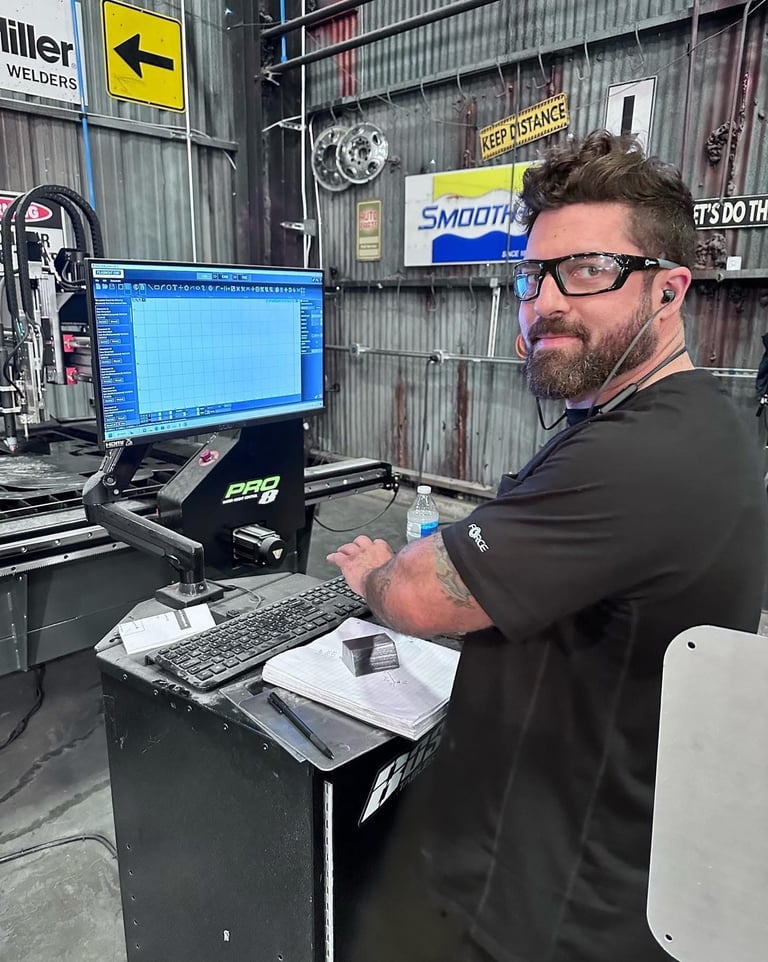 don abenante technician using a CNC machine control console in a fabrication workshop.