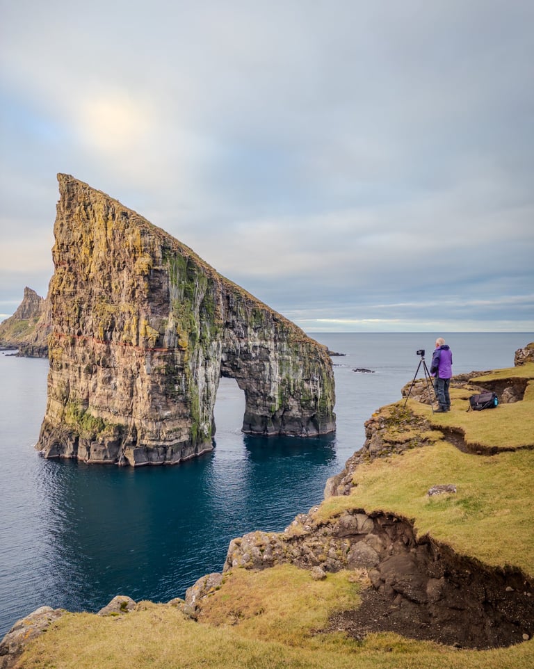 Photographer capturing a shot of Drangarnir in the Faroe Islands