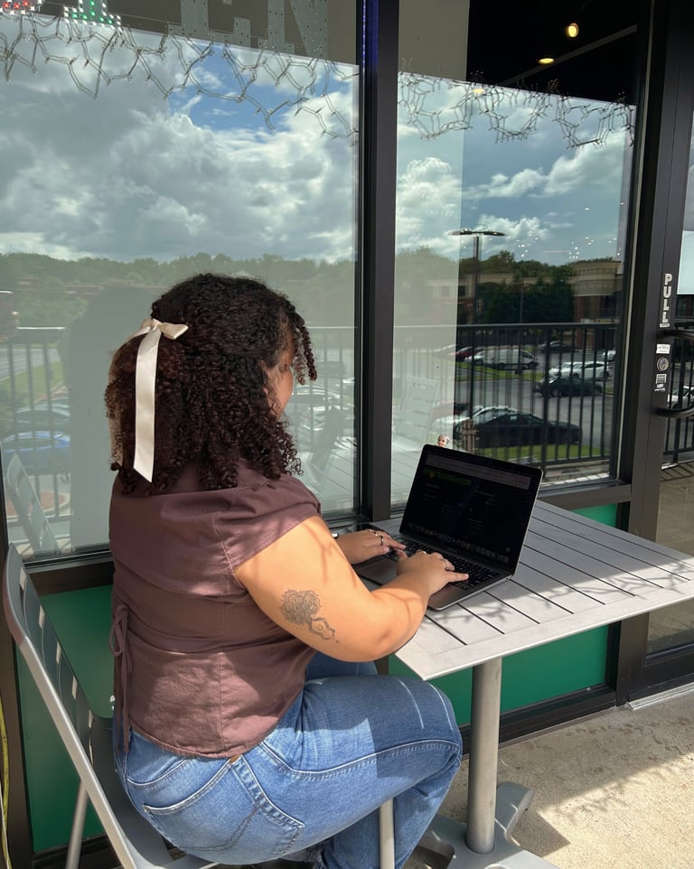 a woman sitting at a table with a laptop