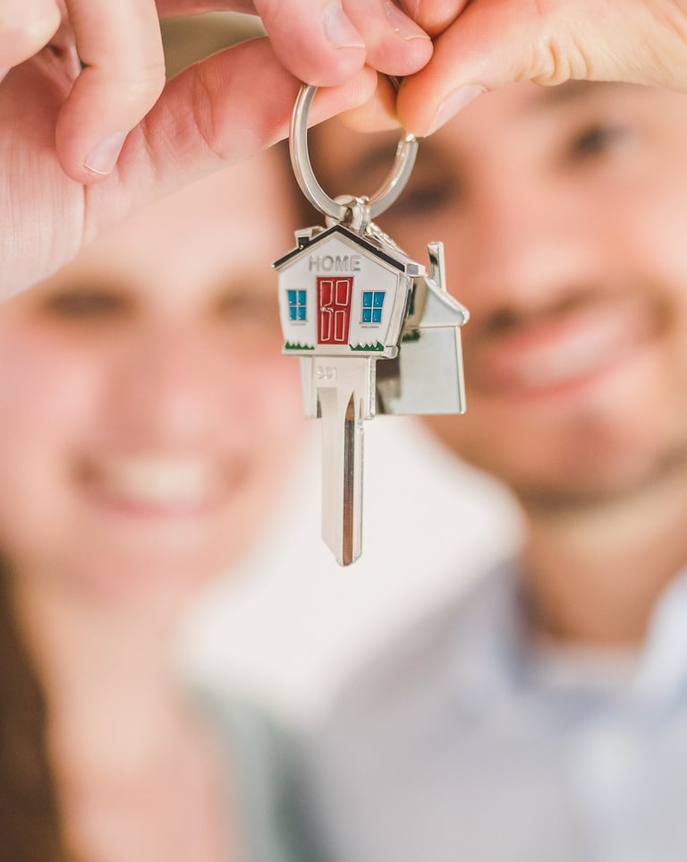 happy couple holding keys to a house after reading the guidebook created your neighbourhood surveyor