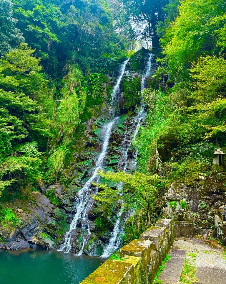 Twin waterfall flowing side by side in a forested valley in Nagasaki, creating a serene and spiritua