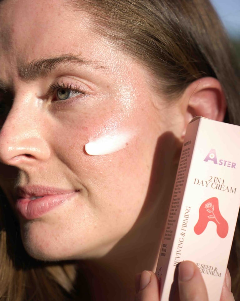 Woman applying Aster 2-in-1 Day Cream on her face, showing healthy glowing skin with pink box.