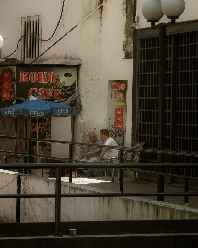 Two men sit outside Beirut Cafe in a local street scene beirut Lebanon Photographer and photography