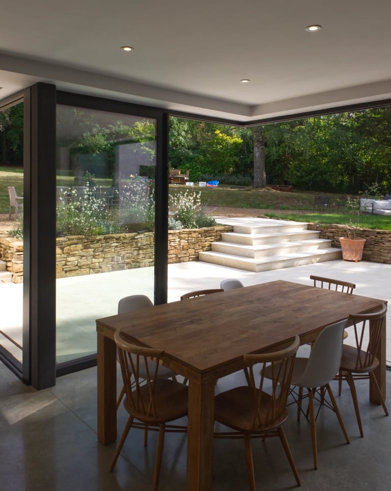 Interior dining space with indoor outdoor living. Cantilevered corner sliding doors.