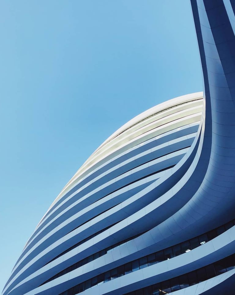 a building with a large curved building in the background