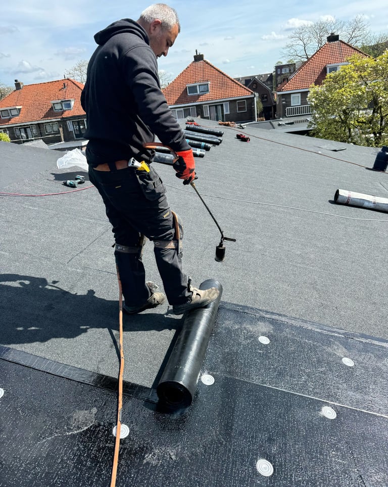 Dakdekker aan het werk op een plat dak in Almere