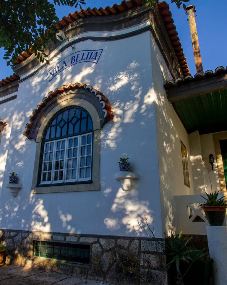 Historic Vila Belita architecture with arched windows and terracotta roof in sunlight.