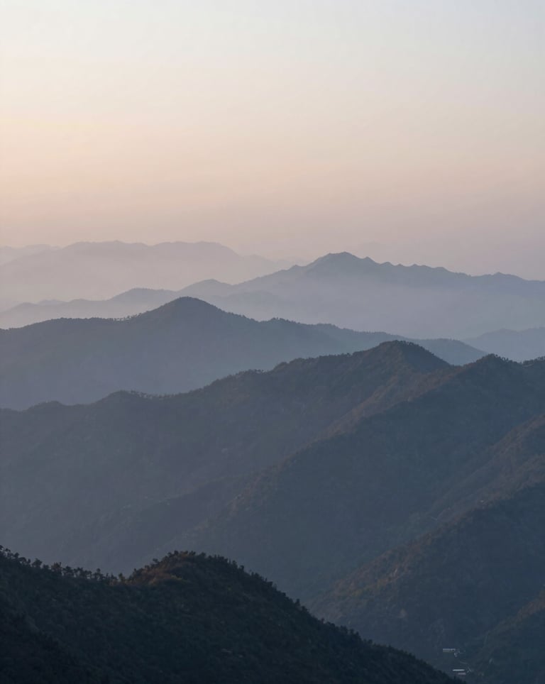 A wide landscape shot of a misty mountain range at dawn, emphasizing quiet confidence and the scale of travel possibilities, utilizing #4A7B8E tones.