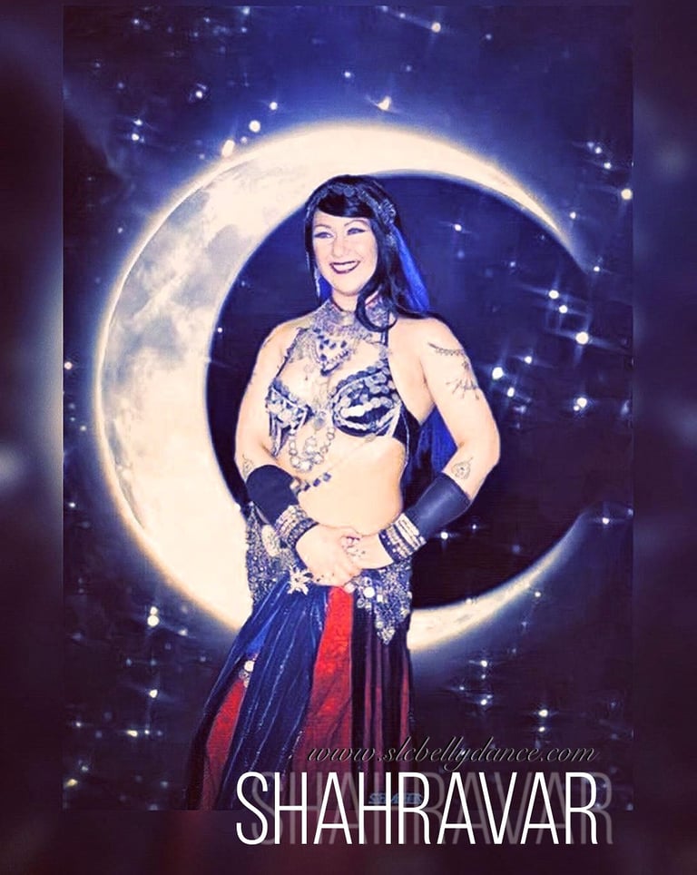 Shahravar bellydancer wearing traditional coin costume with red and lapis costume with cresent moon