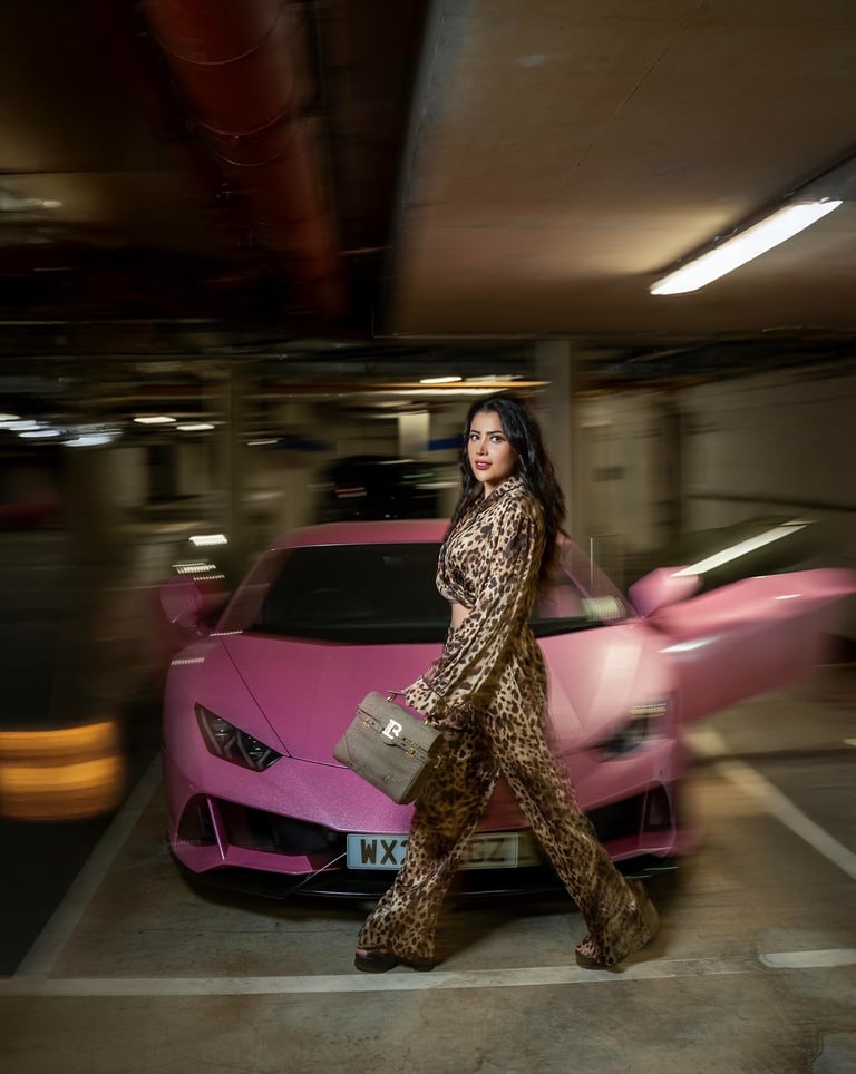 Model walking past pink sports car in a luxury fashion shoot by Fred Art Studio.