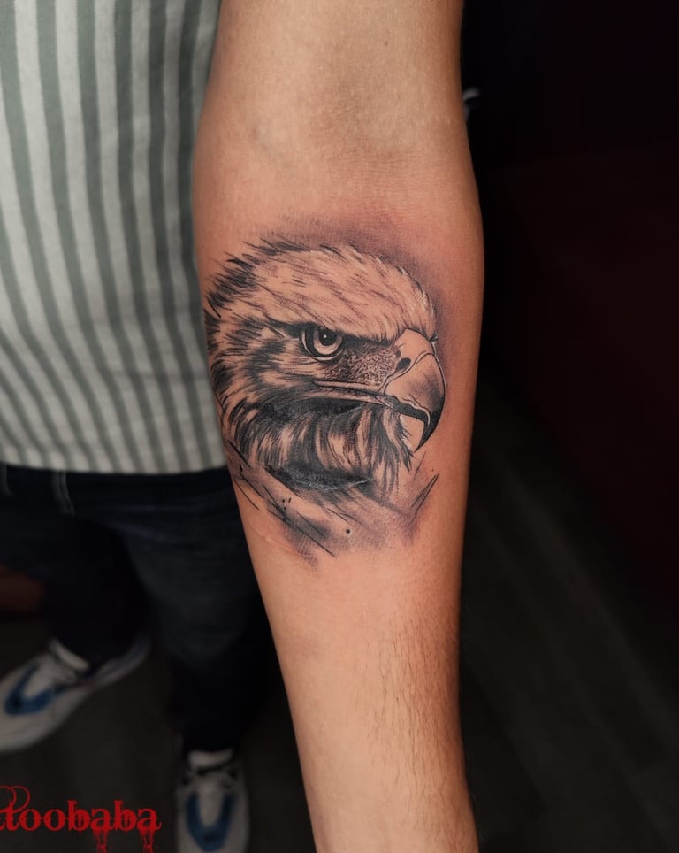 A client smiling and showing off their newly completed tattoo from Tattoo Baba.