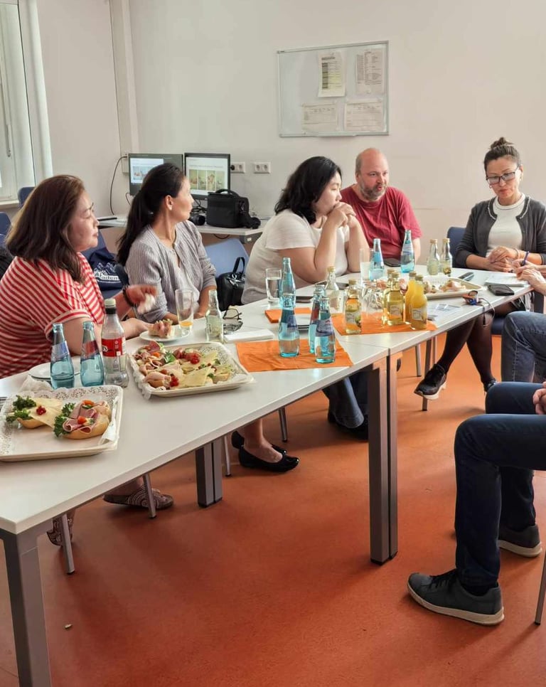 Diverse colleagues sharing lunch and snacks at a business meeting table in an office.