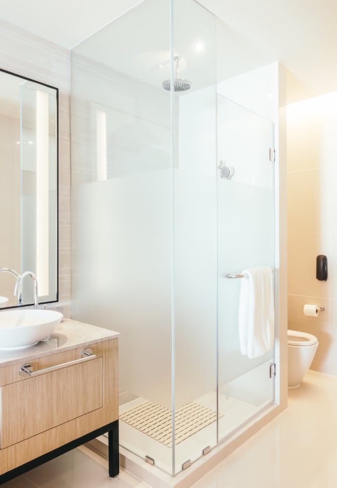 Contemporary bathroom with frosted glass shower and wooden vanity – finished look after a cracked tr