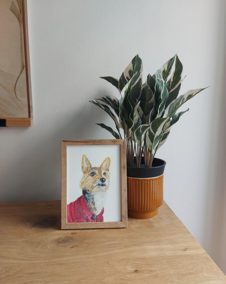 A5 framed realistic colored pencil drawing of a dog portrait next to a plant