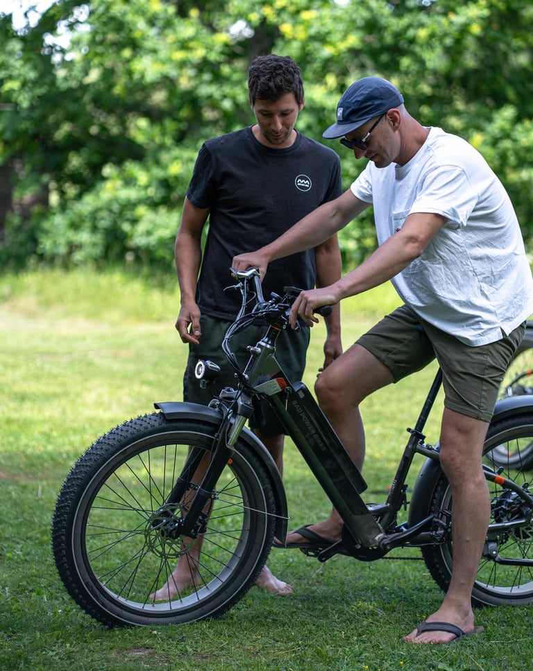 a man standing next to a man on a electric bike