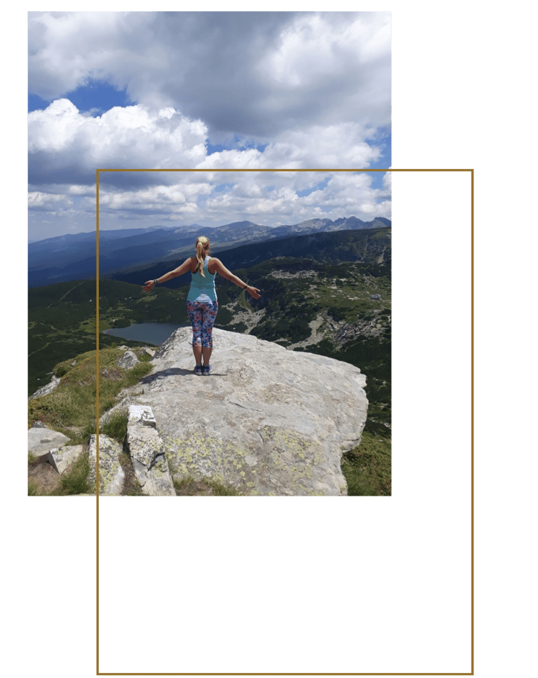 Martina standing on a rock in the mountains.