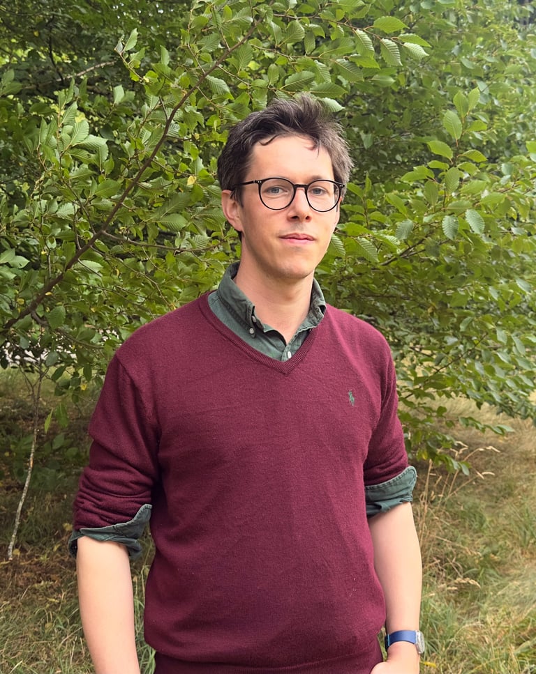 Tyler Hatwell, Psychotherapist & trainer, stood outside on a background of nature