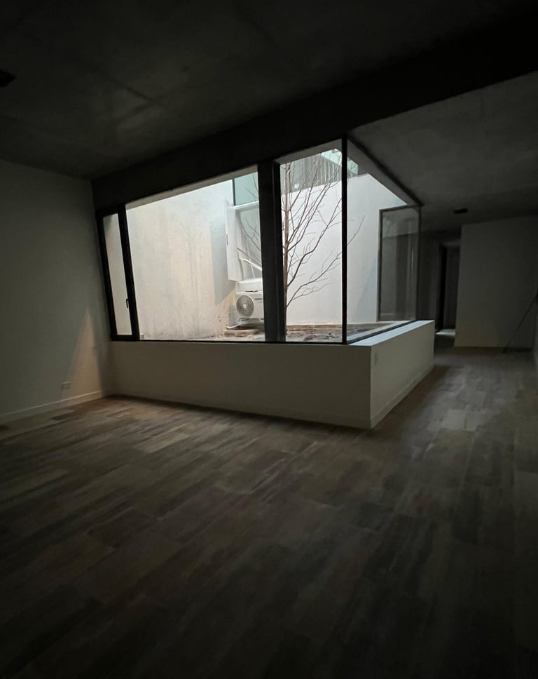 a room with a large window and a tree in the background