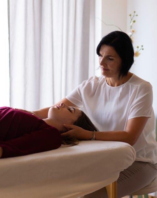 Person liegt auf einer Liege, Hannelore Freischlager macht IKA Craniosacrale Körperarbeit