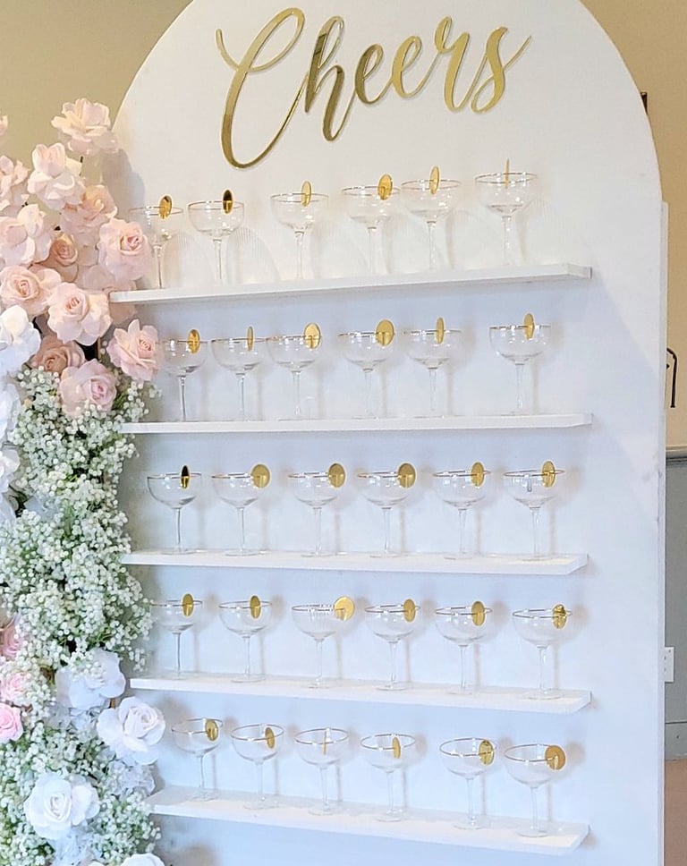 White champagne with a pink and white floral arrangement and champagne flutes