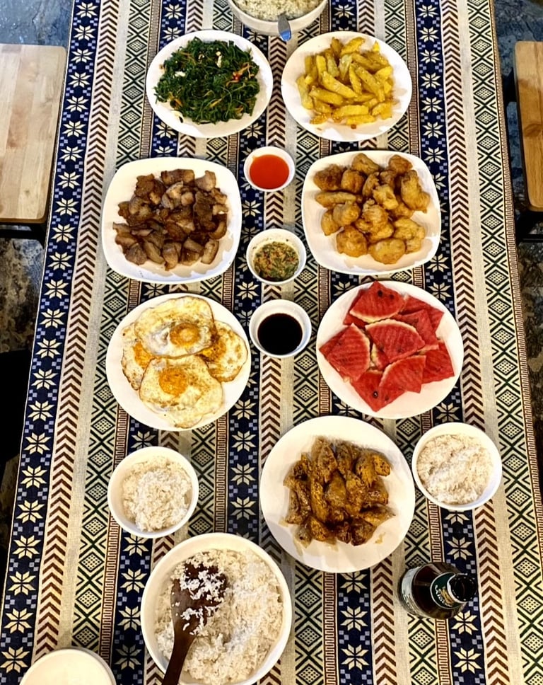a table with plates of food and a bowl of rice