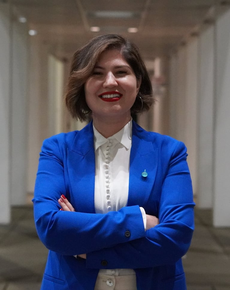 Blue Pen education consultant founder in a blue blazer and white blouse, smiling with arms crossed