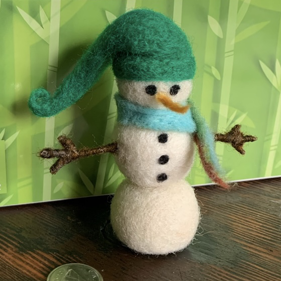 Snowman with blue green scarf and green Cap.