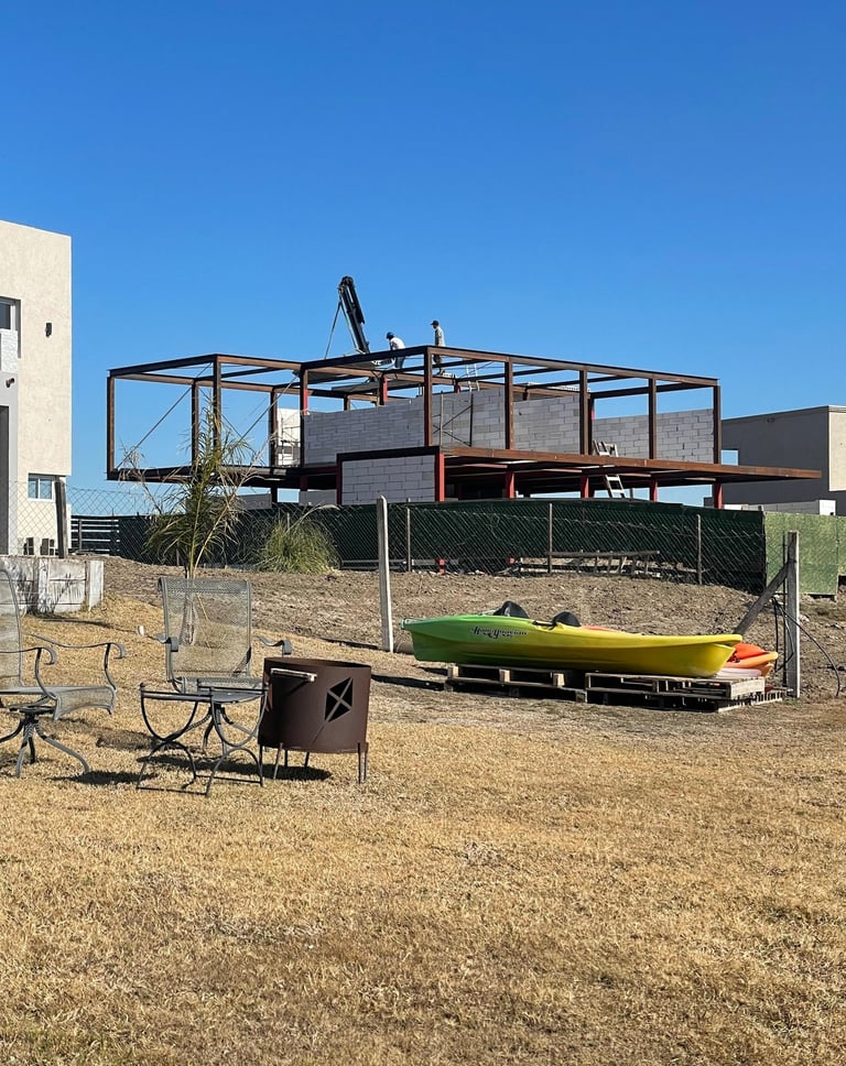 Un hombre de pie en una cubierta con un barco al fondo.