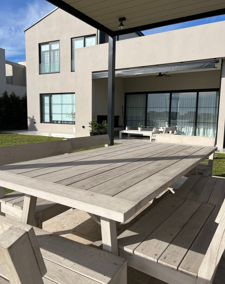 Una mesa con una mesa y sillas frente a una casa.