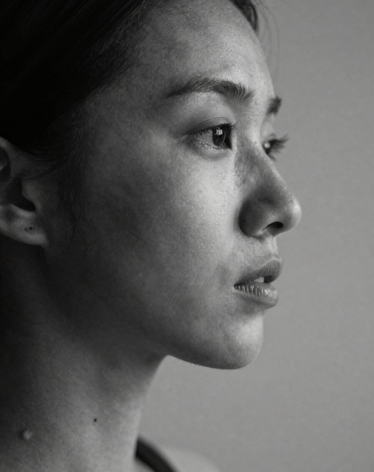 Detailed study of light and shadow on a human subject in a North American studio. Elegant composition emphasizing shape and essence. Black and white aesthetic with rich charcoal values.