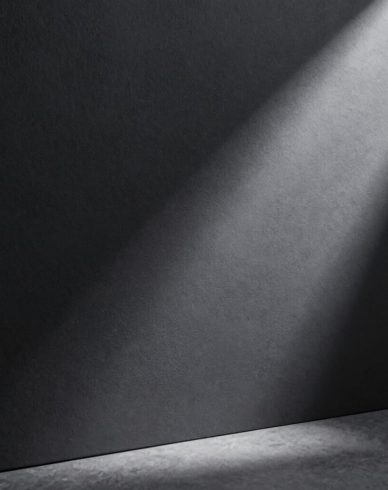 A clean, minimalist composition showing a single thin ray of light hitting a textured charcoal surface, elegant atmosphere, professional studio shot, European / Spanish style.